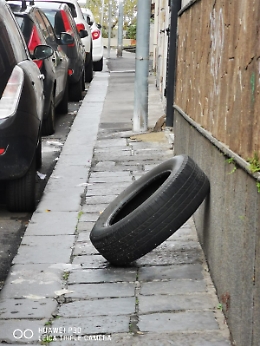 Catania, copertone auto buttato sul marciapiede