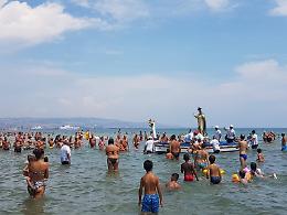 Un momento di fede tra i bagnanti alla Plaia di Catania con la processione dell'Assunta