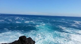 Catania, lunghe scie di schiuma al largo della scogliera