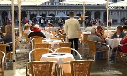 Venezia, turisti al bar con l'acqua alta