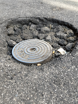 Allarme in via Papale a Catania: buca si allarga e tombino scoperto mettono a rischio auto e due ruote