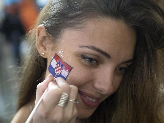 Russia's soccer fan is painted her face in Croatia's national flag after Croatia won the semifinal soccer match between Croatia and England during th