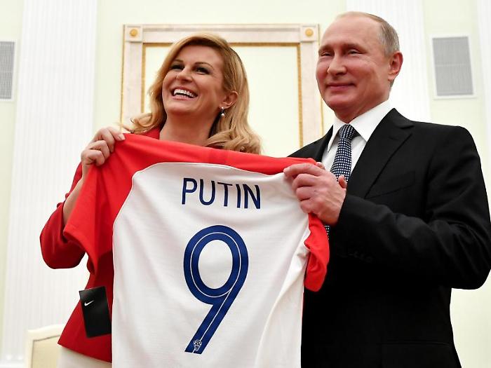 epa06889924 Croatian President Kolinda Grabar-Kitarovic (L) presents a t-shirt to Russian President Vladimir Putin (R) during their meeting at the Kr