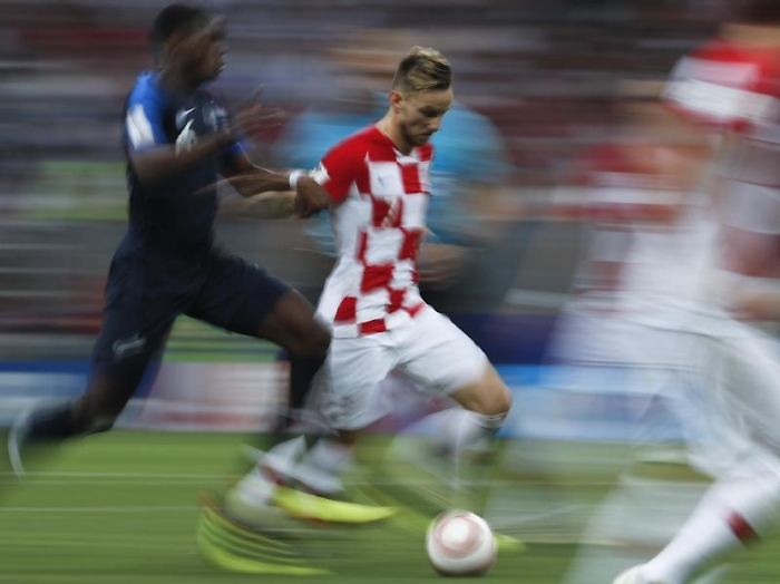 In this photo taken with slow shutter speed Croatia's Ivan Rakitic is challenged by France's Paul Pogba, left, during the final match between France 