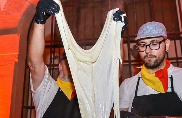 Giuseppe Guddo (a destra) con il pap&agrave; Domenico nascosto dal "lenzuolo della pasta di mozzarella