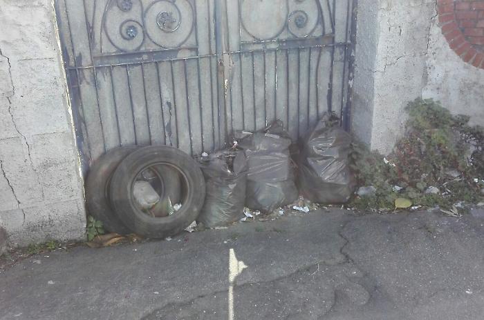 Sacchi di rifiuti ammassati sulla strada del Lungomare di Aci Castello