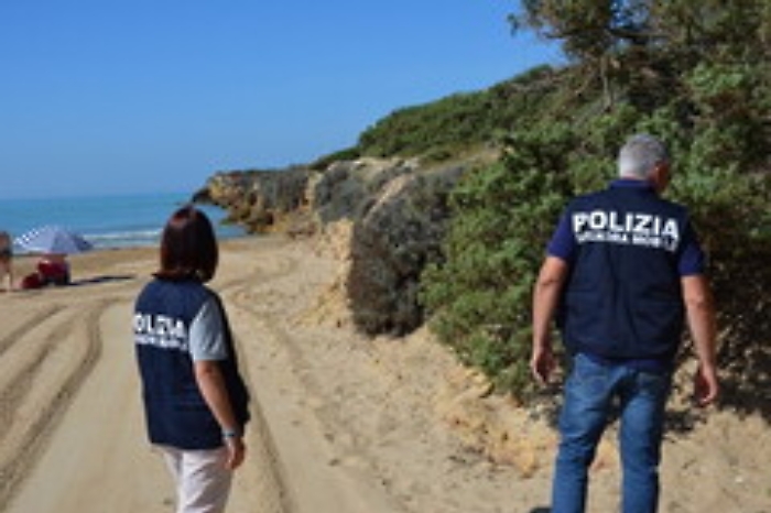 Poliziotti in costume da bagno perlustrano spiaggia per arrestare spacciatore