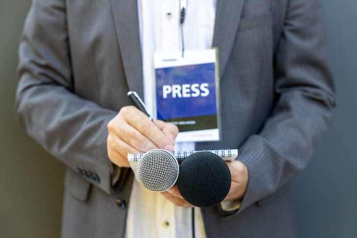 Male,Journalist,At,News,Conference,Or,Media,Event,,Holding,Microphone,