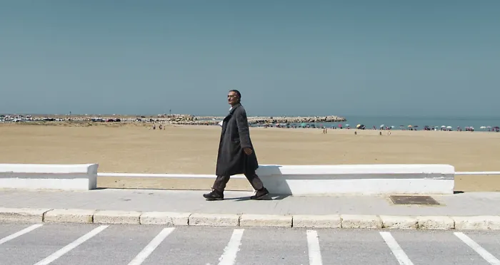 Scoglitti, l'uomo con il cappotto sul lungomare in piena estate